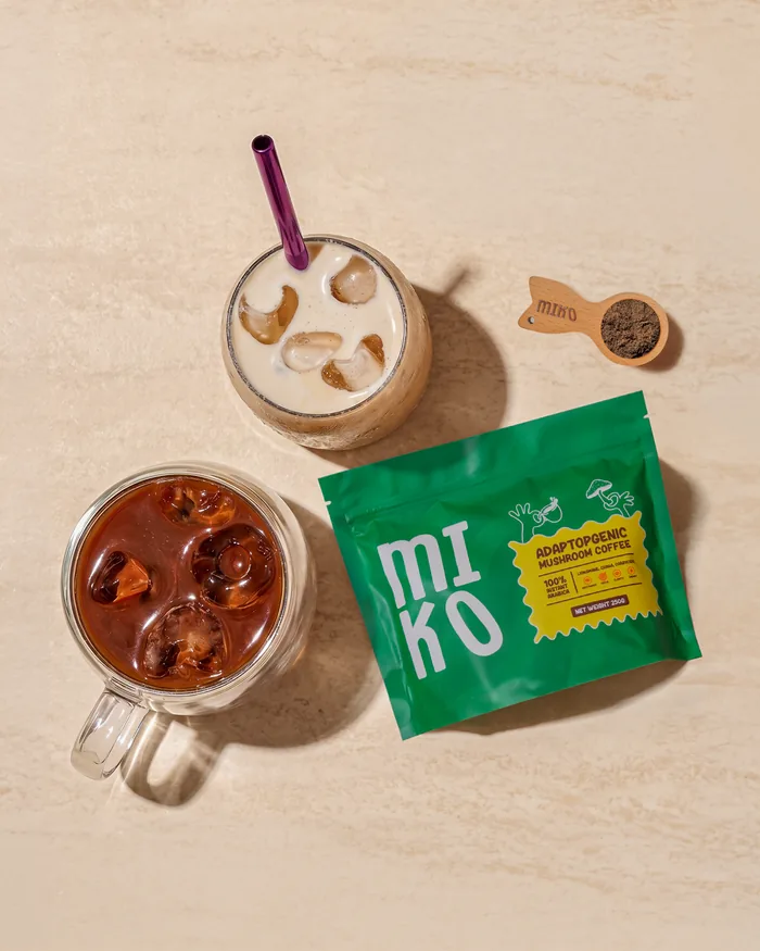 MIKO 250g pouch beside an iced mushroom coffee and wooden spoon